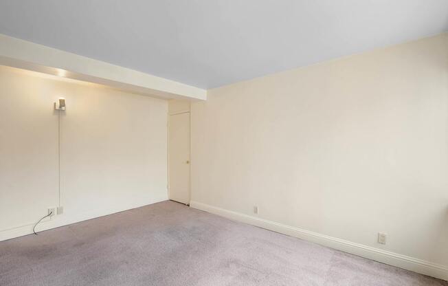 a living room with white walls and a carpet