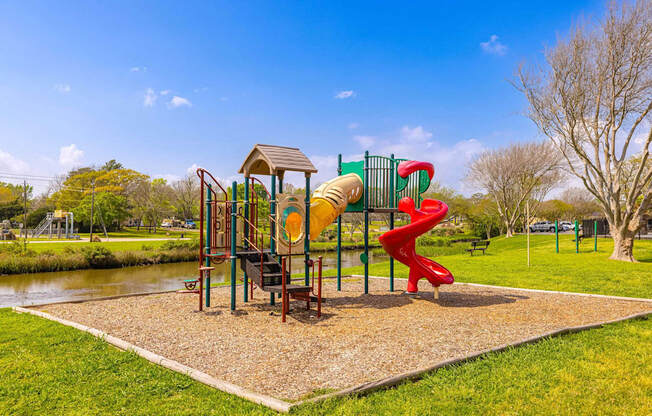 A playground with a red slide and a yellow slide.