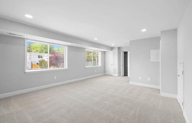 an empty living room with a large window and a door