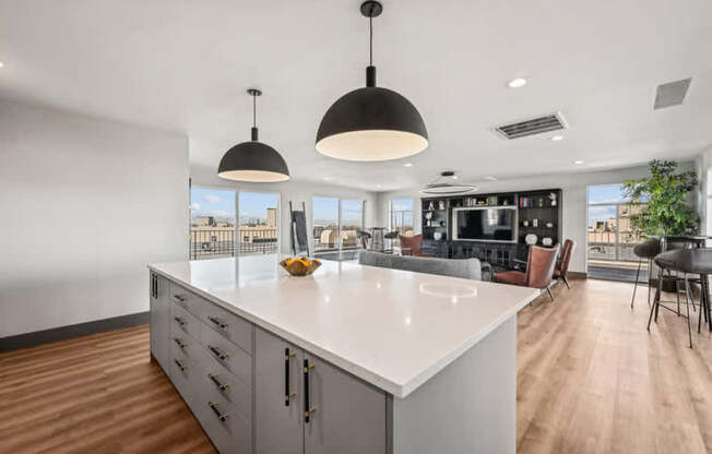 A modern kitchen with a large island and pendant lights.