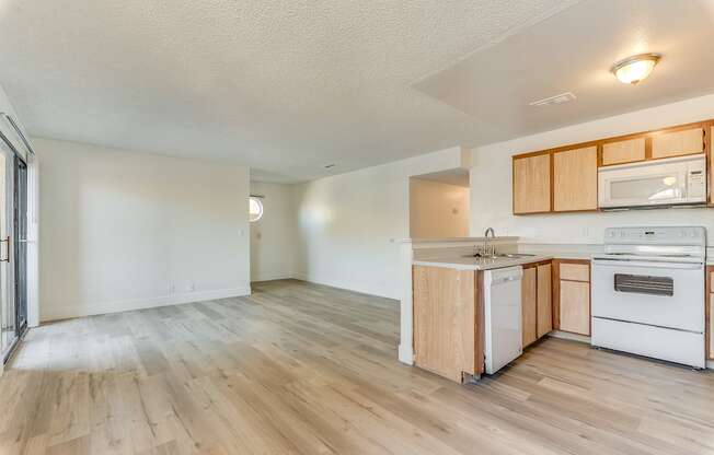 a kitchen and living room with hardwood floors and white walls at Pacific Harbors Sunrise Apartments, Las Vegas, Nevada