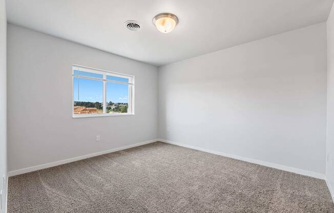A room with a window and a ceiling light.