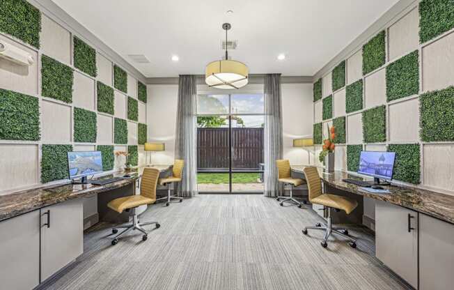 A modern business center with individual workstations and decorative wall panels at Allusion at West University apartments in Houston, TX