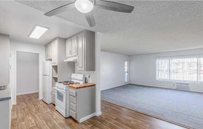 an empty living room with a ceiling fan