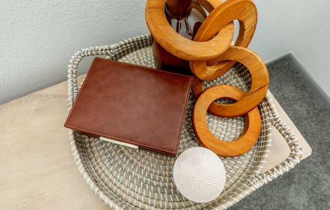 a leather wallet sitting on a table next to a rattan tray