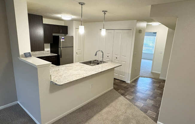 A kitchen with a breakfast bar and dining room at Andover Pointe Apartment Homes in LaVista, NE