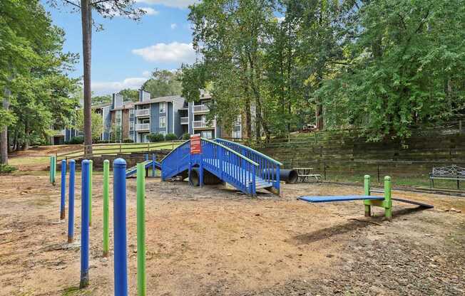 A playground with a blue slide and green and blue poles.
