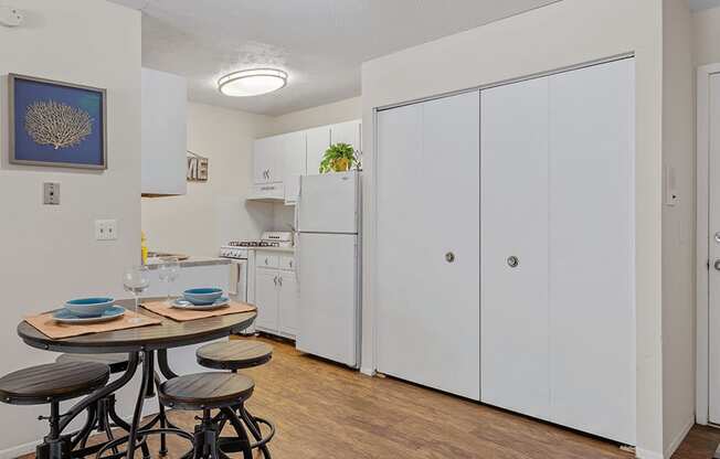 a kitchen with white cabinets and a small table with three stools