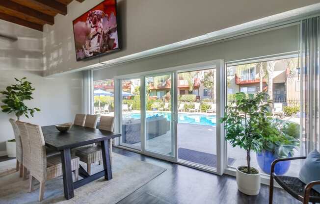 a dining area with a table and chairs and a sliding glass door leading to a pool