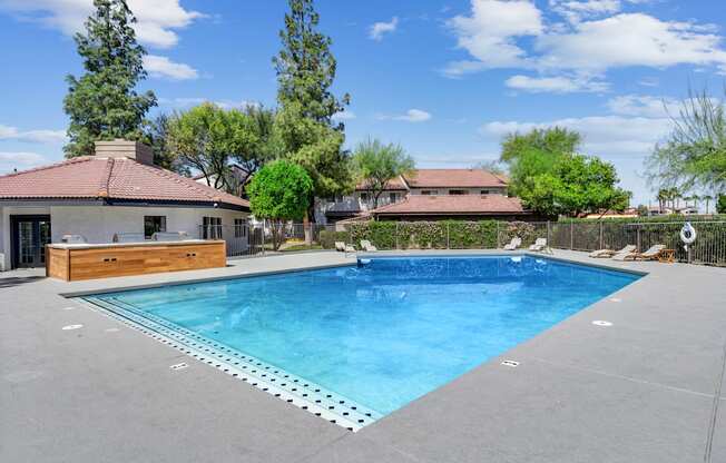 A large swimming pool in a backyard with a house in the background.