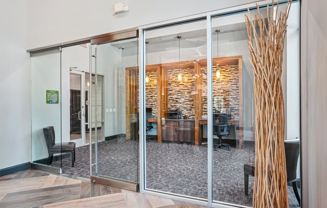 a living room with glass walls and a dining room in the background