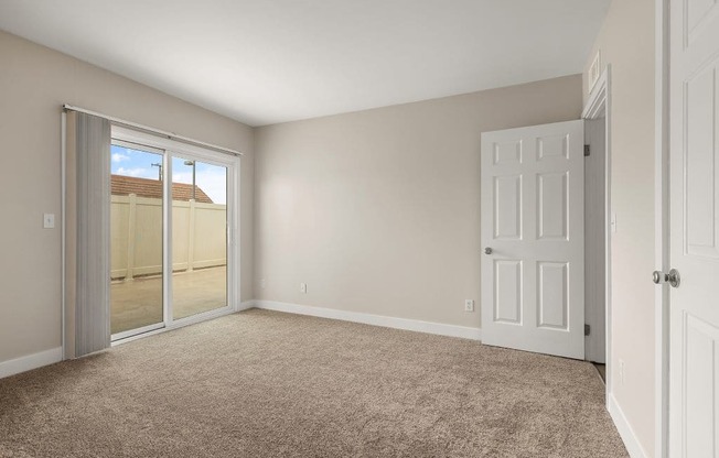 a bedroom with a door leading to a balcony