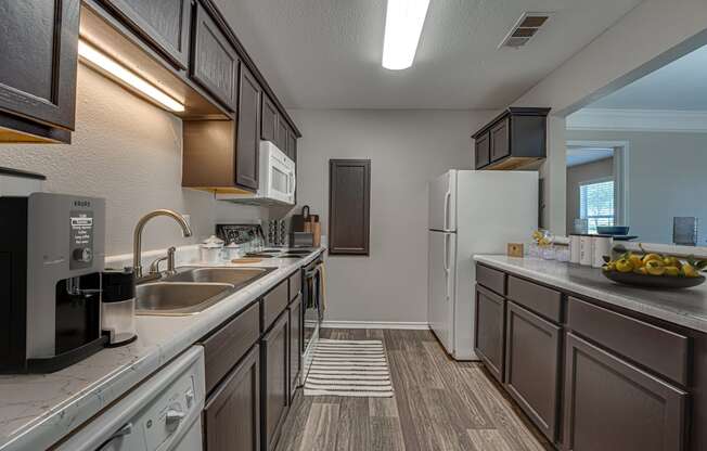 A kitchen with brown cabinets and a white fridge.