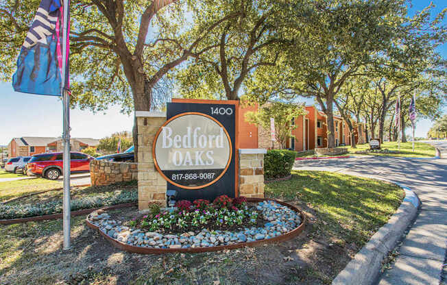 a sign apartments in front of a street with a flag