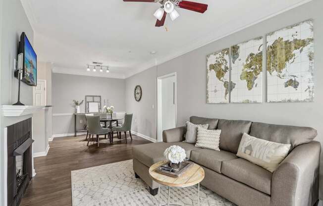 A living room with a grey couch, a coffee table, a fireplace, and a world map on the wall.