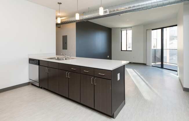 Modern open-concept kitchen and living area with stainless steel appliances.