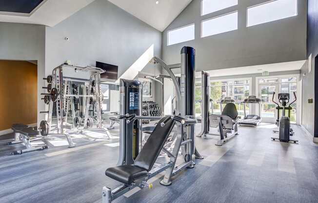 A gym with a variety of equipment including a leg press machine.
