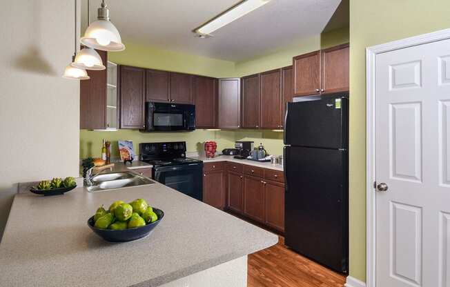 a kitchen with a counter top and a black refrigerator