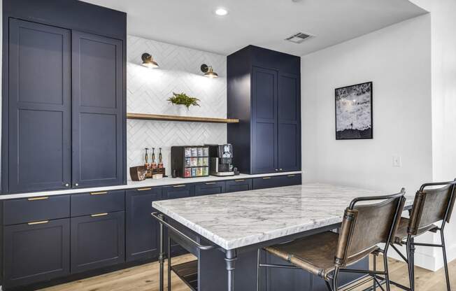 a kitchen with navy cabinets and a marble table