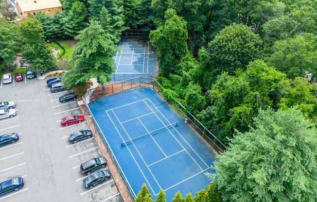 an aerial view of a tennis court and parking lot