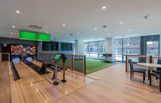 a bowling alley in a building with bowling lanes and tables