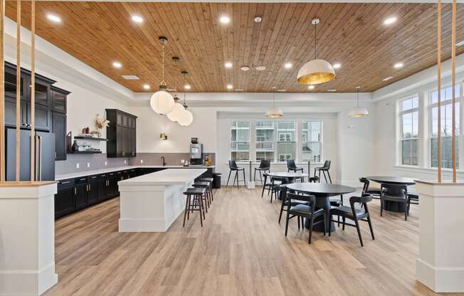 Open kitchen and dining area with tables and chairs and a large windowat Hadley Place Apartments, Pennsylvania