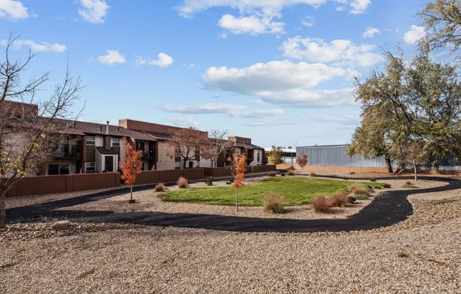 a circle of grass and trees in front of a building