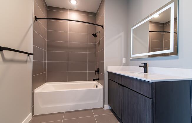 a bathroom with a tub and a sink and a mirror