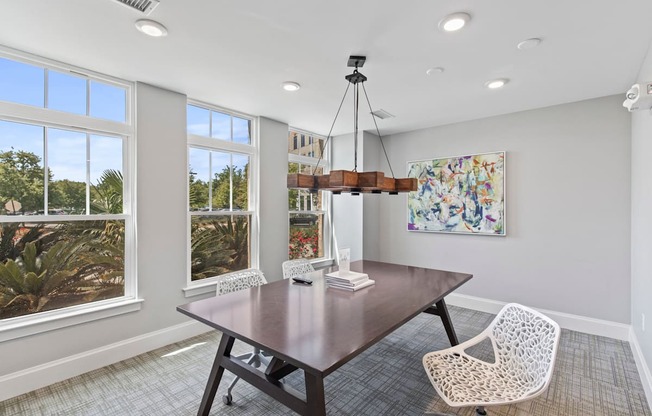 a dining room with a table and chairs and windows