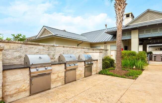 two stainless steel washers and dryers in a stone wall in front of a house