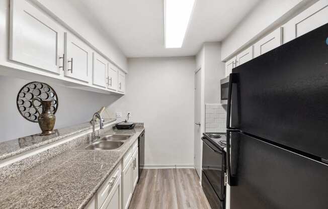 a small bathroom with white cabinets and a sink and a mirror