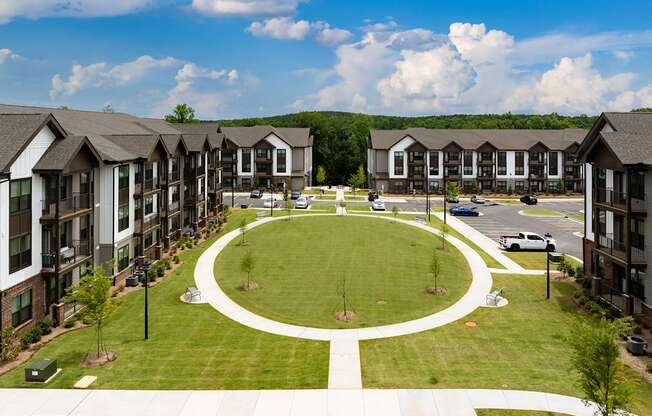 an aerial view of an oval lawn in front of apartment buildings