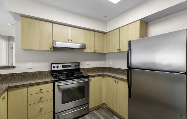 Cozy Kitchen Space with Plank Flooring, Stainless Steel Appliances, and Wood-look Cabinetry at Arabella Apartment Homes, Washington