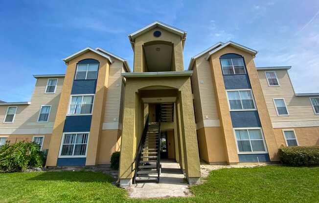 Building Exterior with shrubs in front of it by grass area.