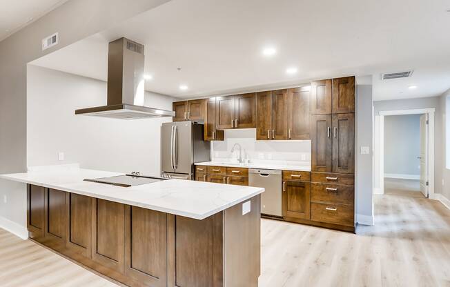 A modern kitchen with wooden cabinets and a white countertop.