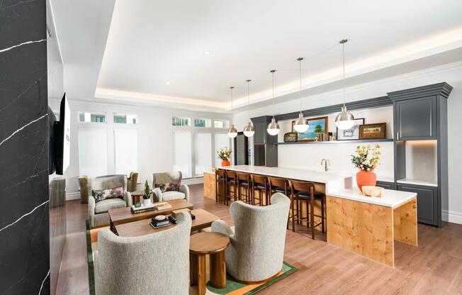 Community gathering space with a long bar, pendant lighting, and open seating arranged for hosting, conversation, and shared moments.