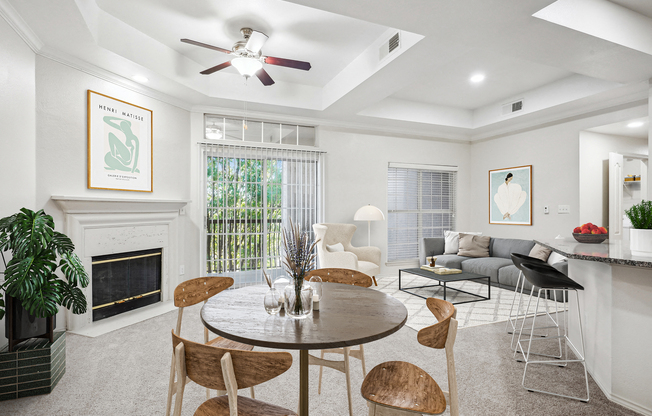 a living room with a table and chairs and a fireplace at La Ventura Apartments, Plano, 75093