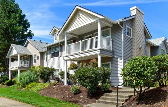 the view of a gray house with a balcony