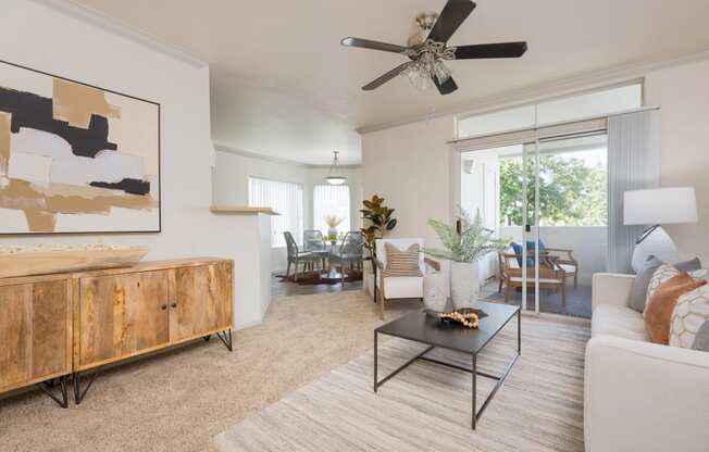 a living room with a couch coffee table and a ceiling fan