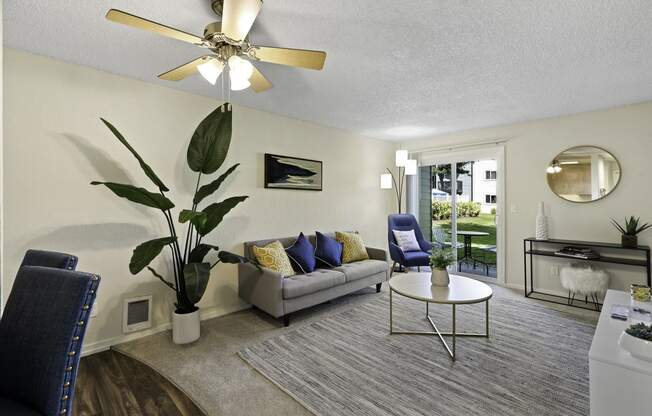 a living room with a couch coffee table and a ceiling fan at Pacific Park Apartment Homes, Edmonds, Washington 98026