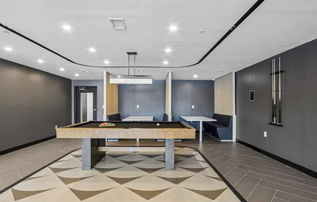 A room with a pool table and a bench.