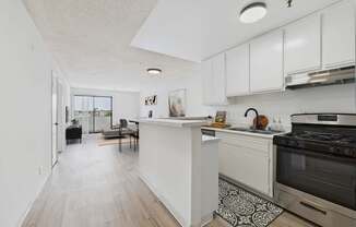A kitchen with a white counter and a black stove.