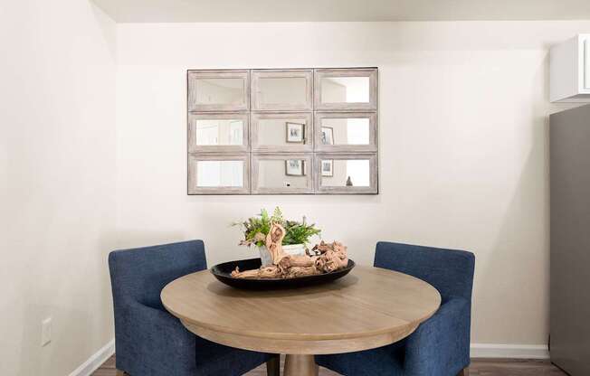 A dining table with two chairs and a decorative plant on it.
