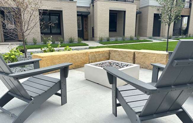 a patio with two chairs and a planter in front of a building at Meridian at CityPlace in Woodbury, MN 55125