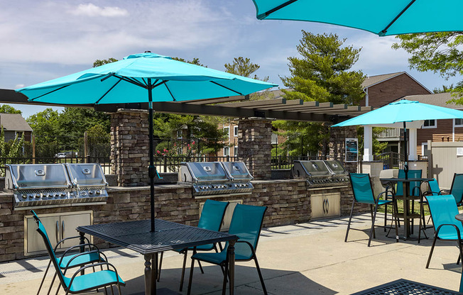 a patio with blue umbrellas and tables with chairs