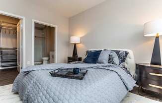 A bedroom with a large bed and a lamp.