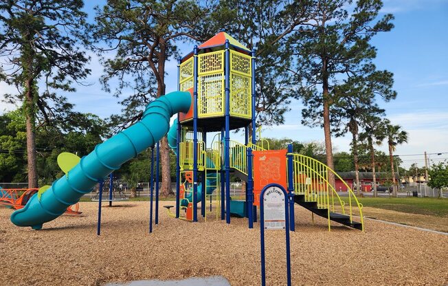 A playground with a blue and yellow slide.