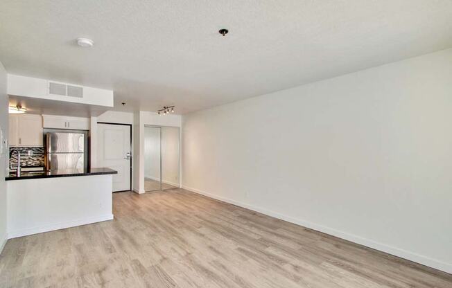 an empty living room with a kitchen in the background  at Masselin Park West, Los Angeles, California