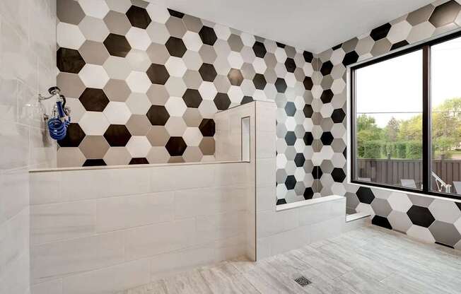 a bathroom with black and white tiles on the wall. Circle Pines, MN Lexington Lofts