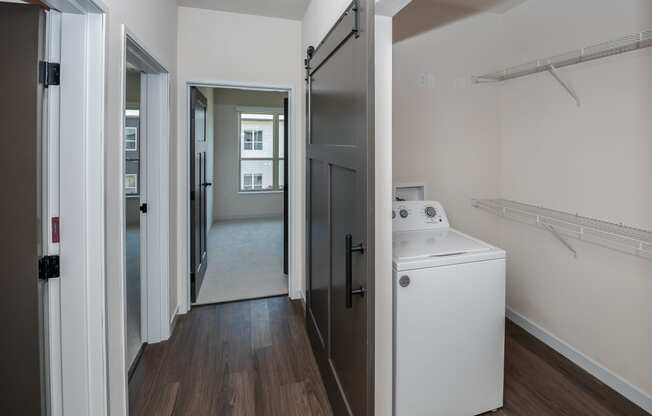 a walk in shower with a wood floor and a white washer and dryer at The Crossings at Windsong, Prescott Valley, Arizona